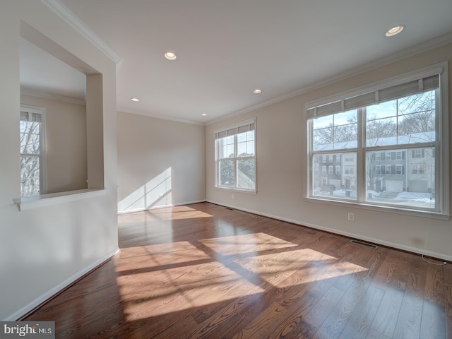 empty room featuring crown molding and hardwood / wood-style flooring