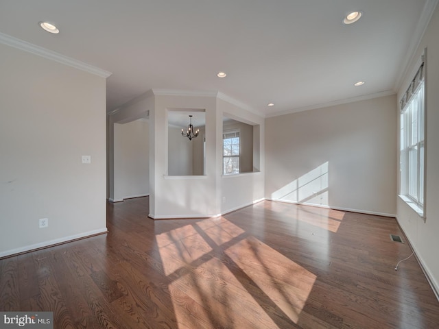 empty room with dark wood-type flooring, ornamental molding, and a chandelier