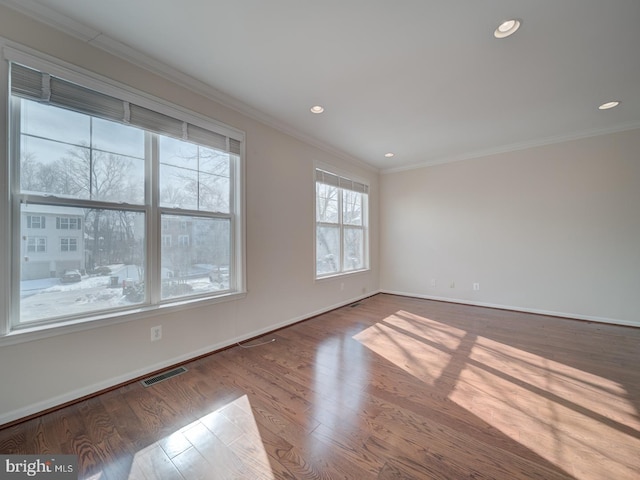 spare room featuring wood-type flooring and ornamental molding