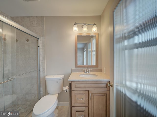 bathroom with vanity, toilet, and a shower with shower door