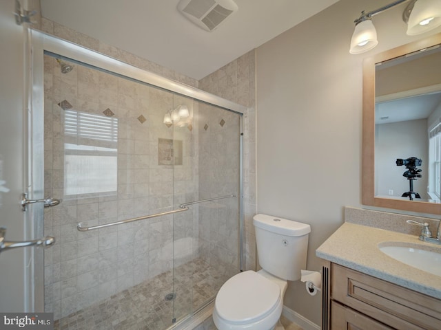 bathroom with vanity, toilet, and a shower with shower door