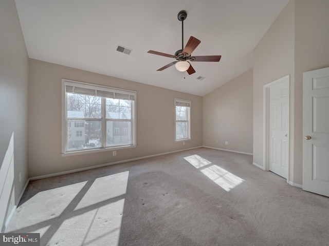 empty room featuring light carpet, vaulted ceiling, and ceiling fan