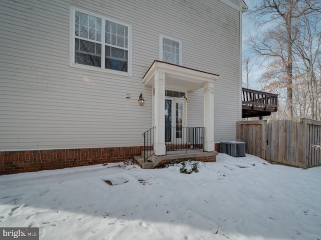 snow covered property entrance with central AC