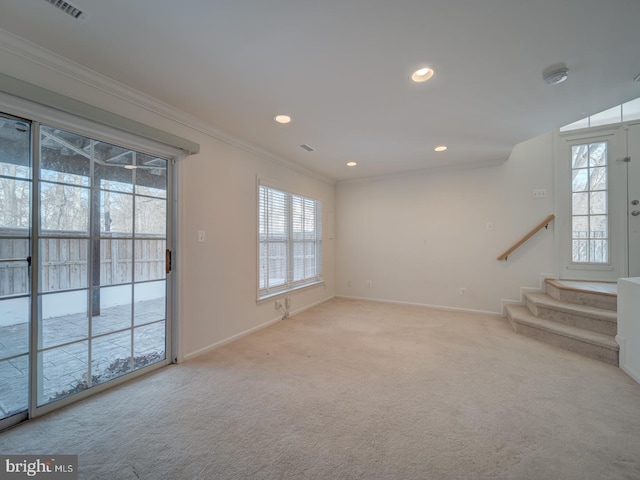 unfurnished living room featuring crown molding, a healthy amount of sunlight, and light carpet