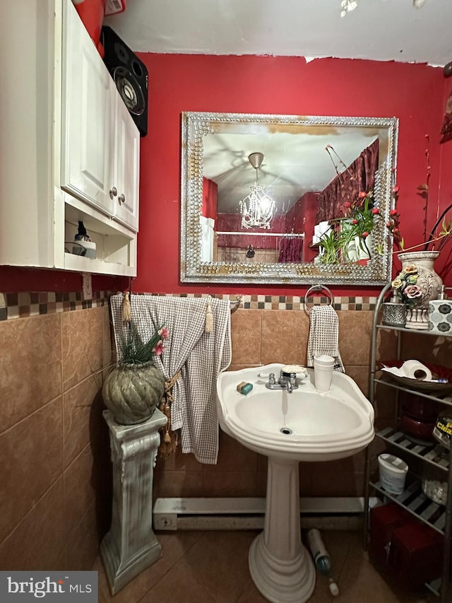 bathroom with a notable chandelier, tile walls, and tile patterned floors