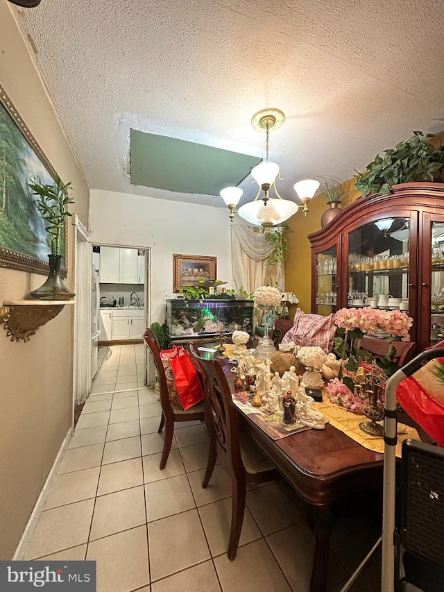 tiled dining room featuring a textured ceiling