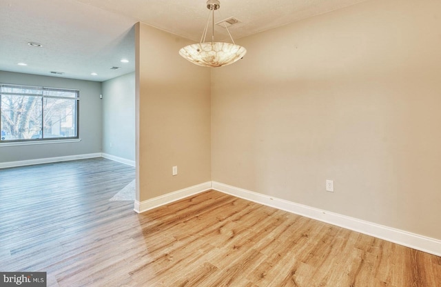 empty room featuring light hardwood / wood-style floors and a textured ceiling