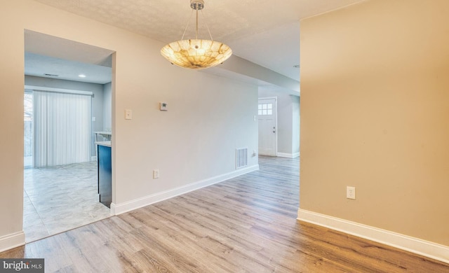 unfurnished dining area featuring light wood-type flooring