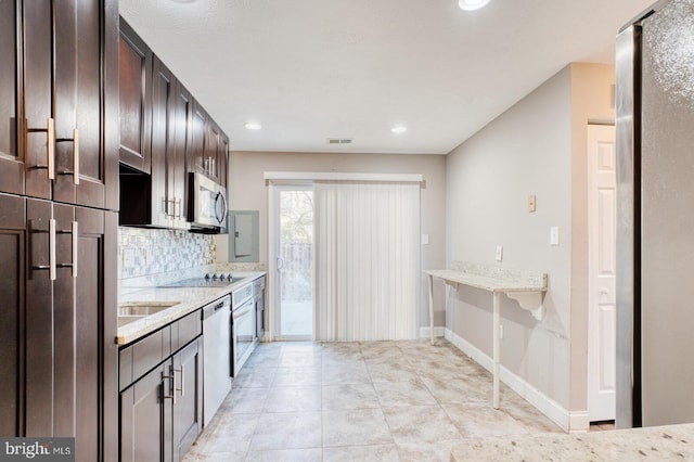 kitchen featuring dark brown cabinetry, stainless steel appliances, decorative backsplash, light stone counters, and electric panel