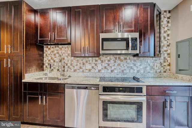 kitchen featuring sink, light stone countertops, appliances with stainless steel finishes, and decorative backsplash