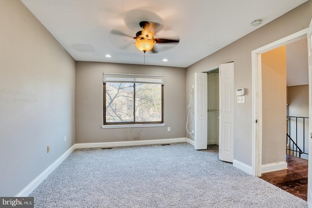 unfurnished bedroom with ceiling fan and dark carpet