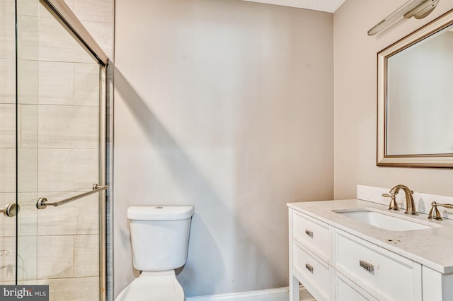 bathroom featuring toilet, vanity, and walk in shower