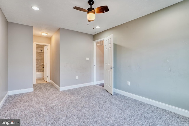 unfurnished bedroom featuring ceiling fan, light colored carpet, and ensuite bathroom