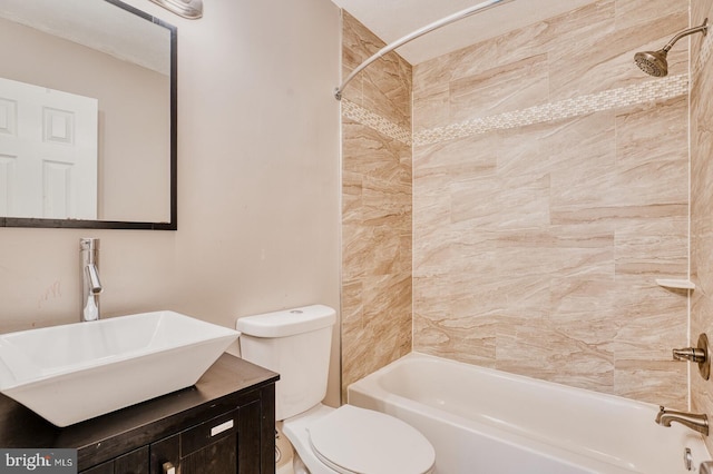 full bathroom featuring tiled shower / bath combo, toilet, and vanity