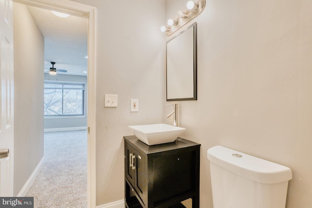 bathroom featuring ceiling fan, toilet, and vanity