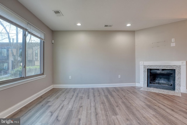 unfurnished living room with light hardwood / wood-style floors and a wealth of natural light