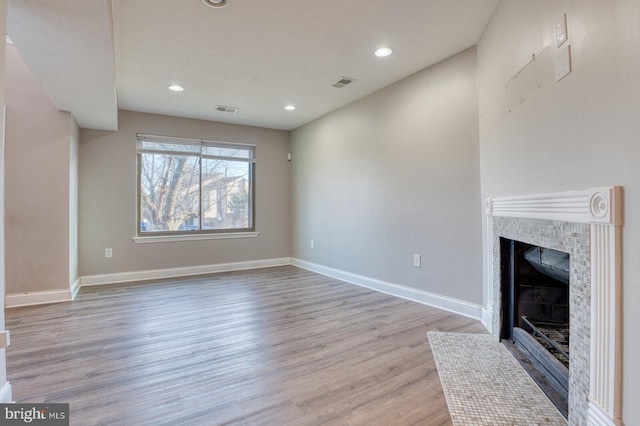 unfurnished living room with light hardwood / wood-style floors and a fireplace