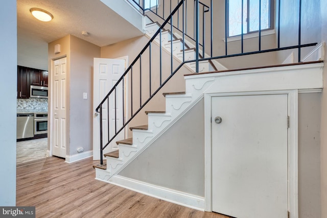 stairway with hardwood / wood-style flooring and a textured ceiling