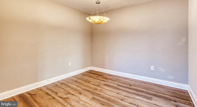 unfurnished room with wood-type flooring and a textured ceiling