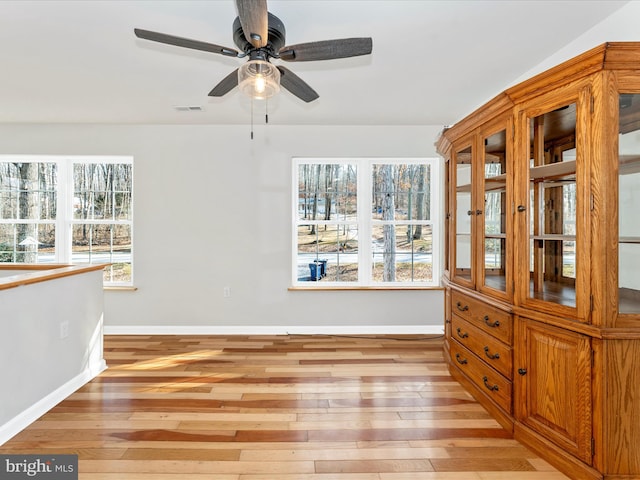 unfurnished dining area with ceiling fan and light hardwood / wood-style flooring