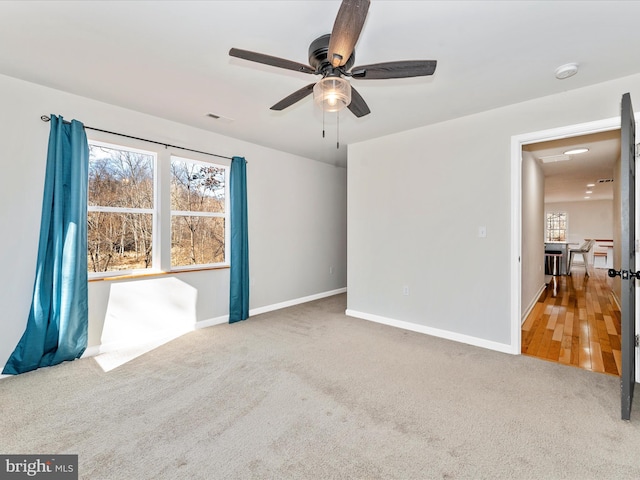 carpeted spare room with plenty of natural light and ceiling fan