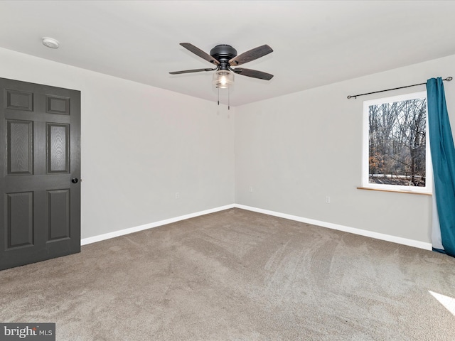 carpeted spare room featuring ceiling fan