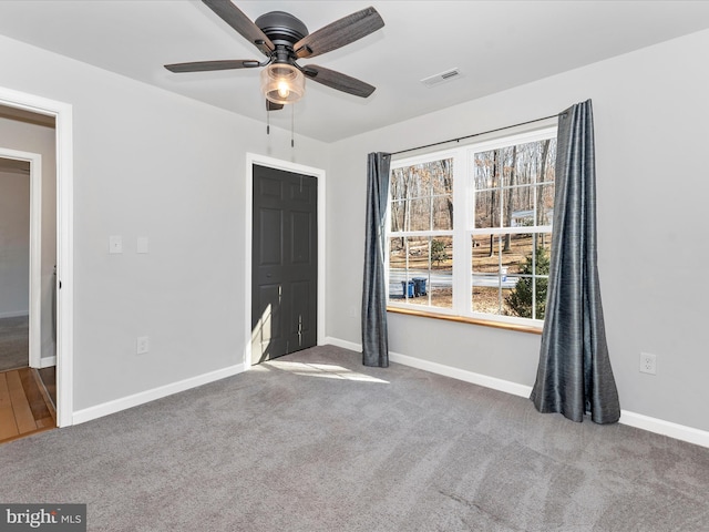 unfurnished room featuring ceiling fan and carpet