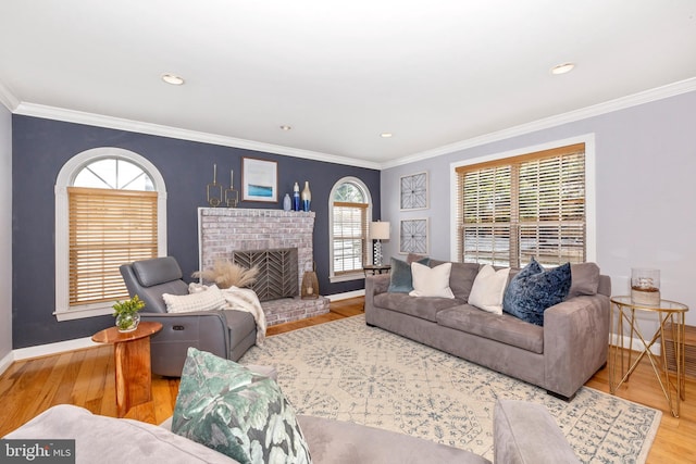 living room with hardwood / wood-style flooring, a brick fireplace, and crown molding