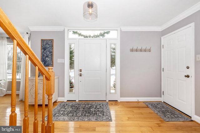 foyer entrance with plenty of natural light, wood-type flooring, and ornamental molding