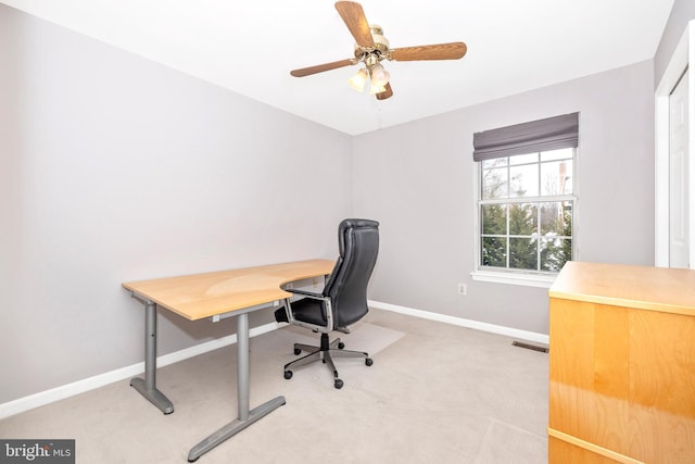 carpeted office space featuring ceiling fan