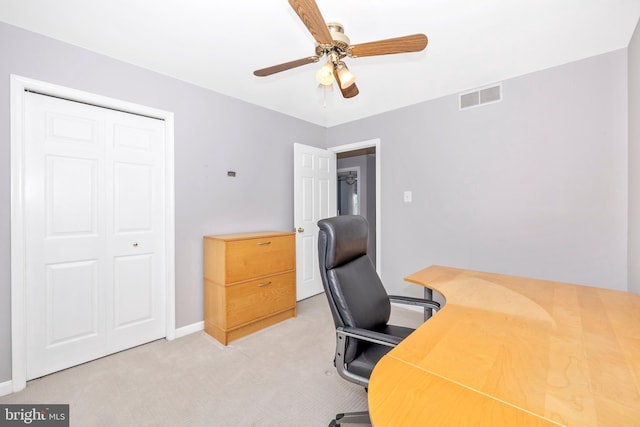 carpeted office space featuring ceiling fan