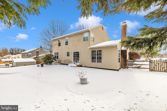 view of snow covered rear of property