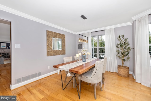 dining space featuring light hardwood / wood-style flooring and ornamental molding