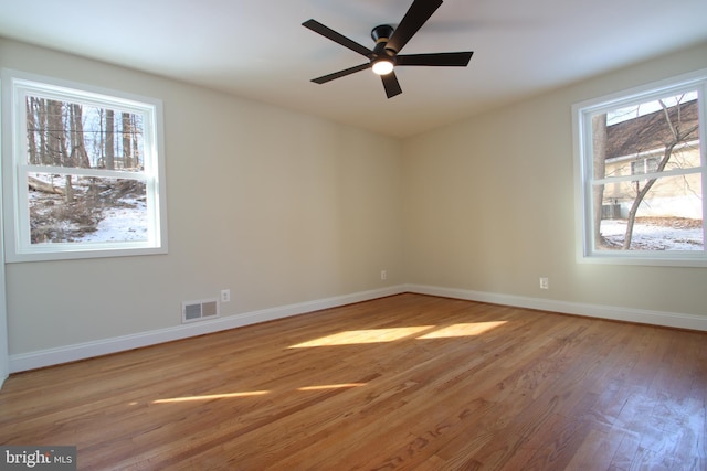 unfurnished room featuring light wood-style flooring, visible vents, ceiling fan, and baseboards