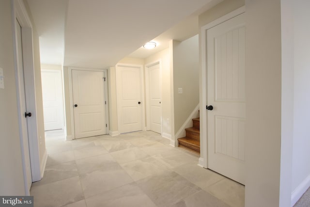 hall with baseboards and stairway