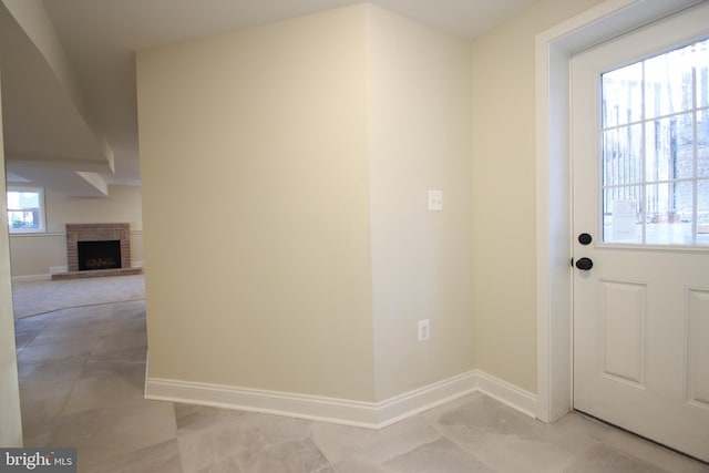 entryway with a brick fireplace and baseboards