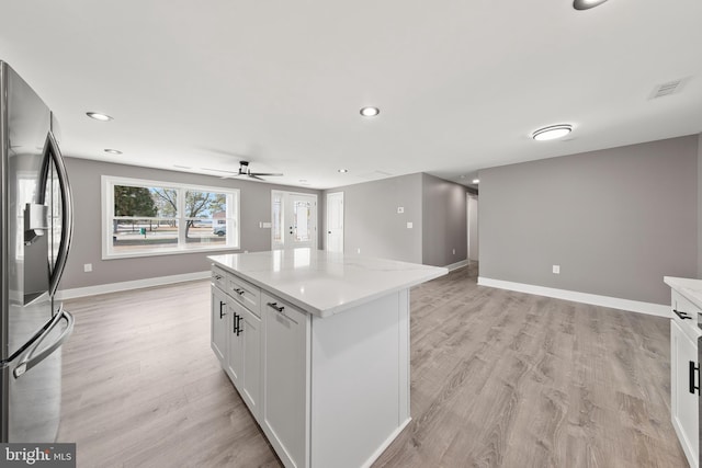 kitchen with light wood finished floors, baseboards, white cabinetry, and stainless steel refrigerator with ice dispenser