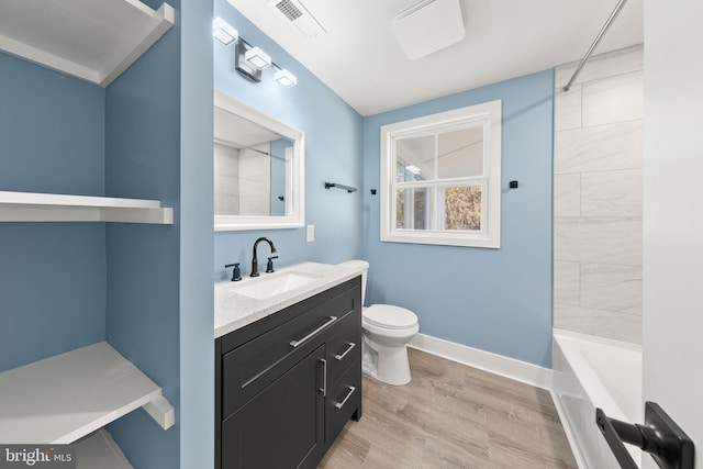 bathroom featuring vanity, wood finished floors, visible vents, baseboards, and toilet