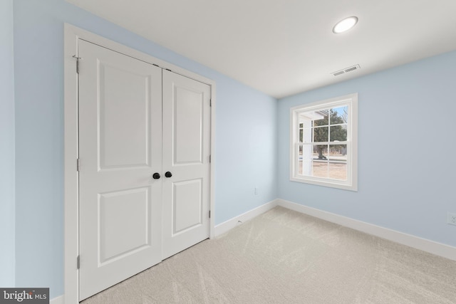 unfurnished bedroom featuring visible vents, recessed lighting, a closet, carpet, and baseboards