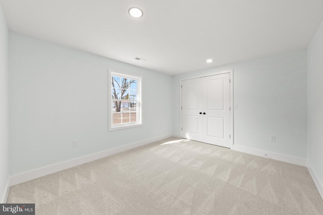 unfurnished bedroom featuring recessed lighting, light colored carpet, visible vents, and baseboards