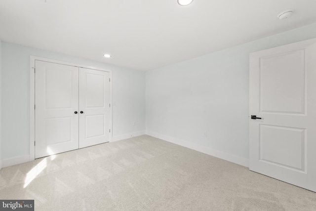 unfurnished bedroom featuring recessed lighting, carpet, baseboards, and a closet