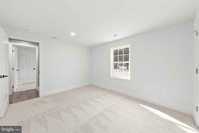 carpeted empty room with visible vents, recessed lighting, and baseboards