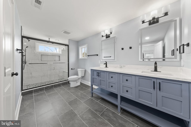 bathroom featuring a marble finish shower, visible vents, toilet, and a sink