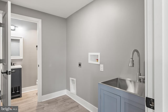 laundry room with light wood finished floors, baseboards, washer hookup, hookup for an electric dryer, and a sink