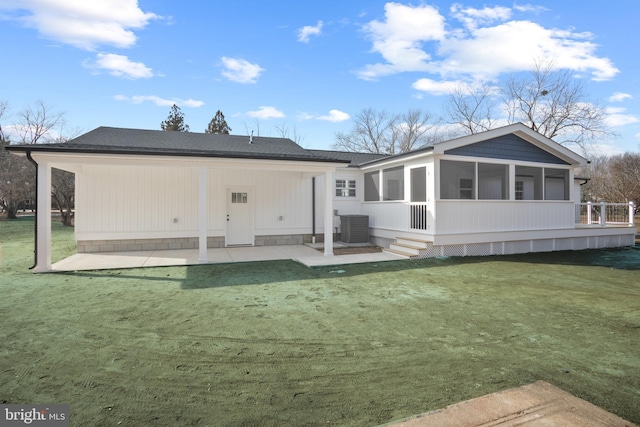 back of house featuring a patio area, a lawn, central AC unit, and a sunroom