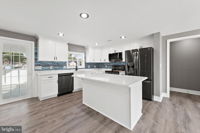 kitchen featuring tasteful backsplash, white cabinets, stainless steel appliances, and a sink