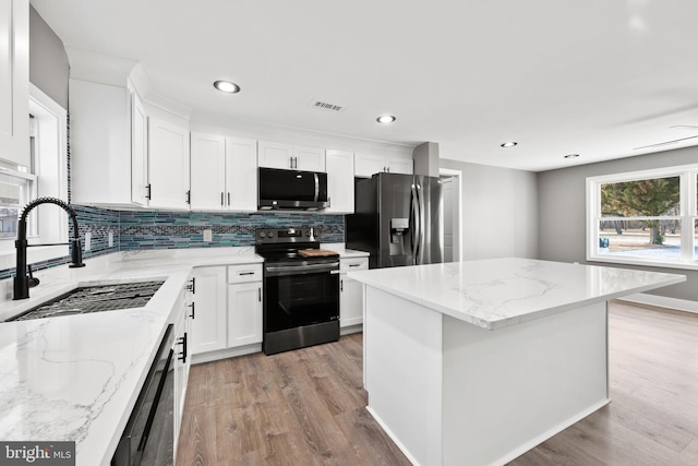 kitchen featuring a sink, light wood-style floors, visible vents, and stainless steel appliances