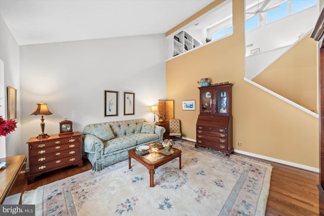 living room with hardwood / wood-style floors and high vaulted ceiling