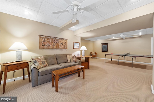 living room featuring ceiling fan, a paneled ceiling, and light carpet