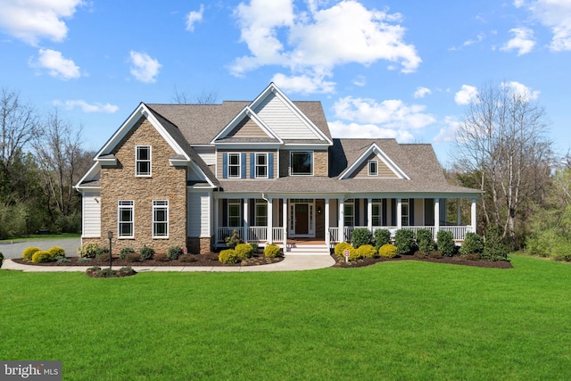 craftsman inspired home featuring covered porch and a front lawn